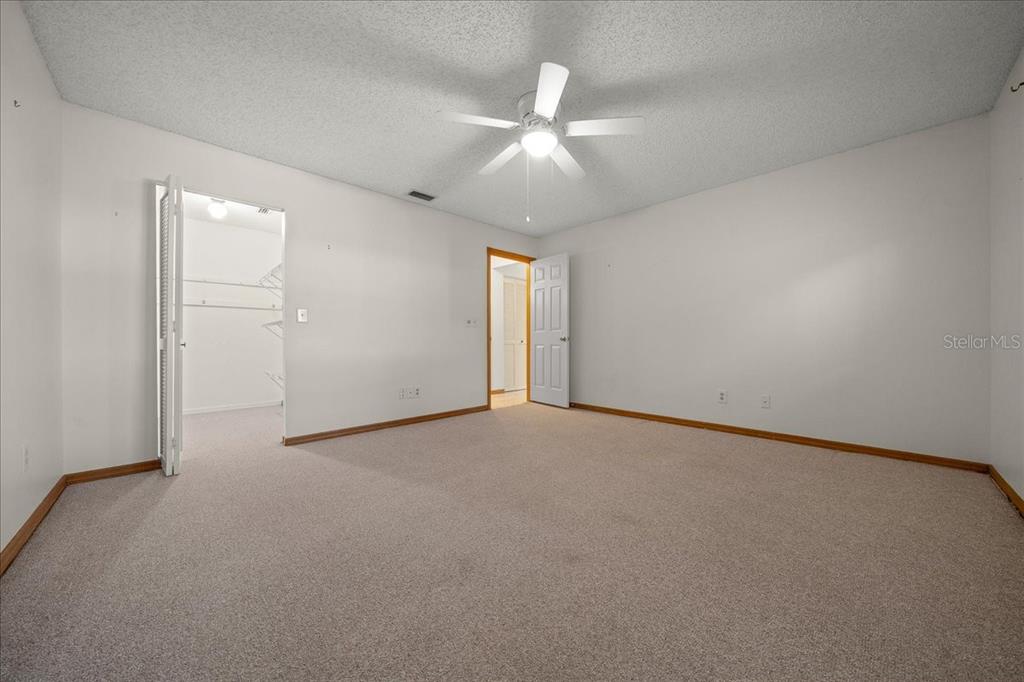 8431 Southwest 93rd Place, Unit A Ocala, FL 34481 - Photo 43 of 56 an empty room with a ceiling fan and a window