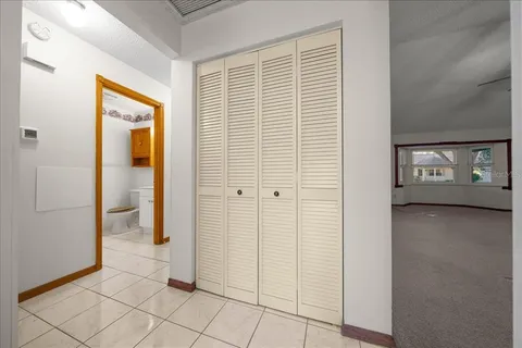 a view of a big room with windows and chandelier fan