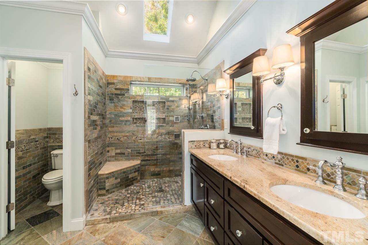 9200 Ranworth Way Raleigh, NC 27615 - Photo 21 of 39 The master bathroom is equipped with a walk-in shower, a double vanity, a private water closet, vaulted ceiling, and a skylight.