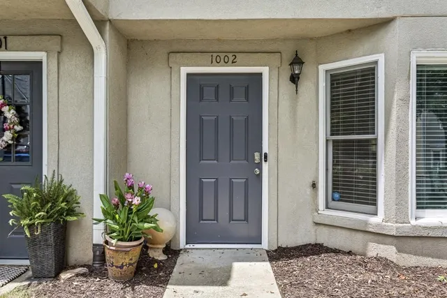 a front view of a house with potted plants