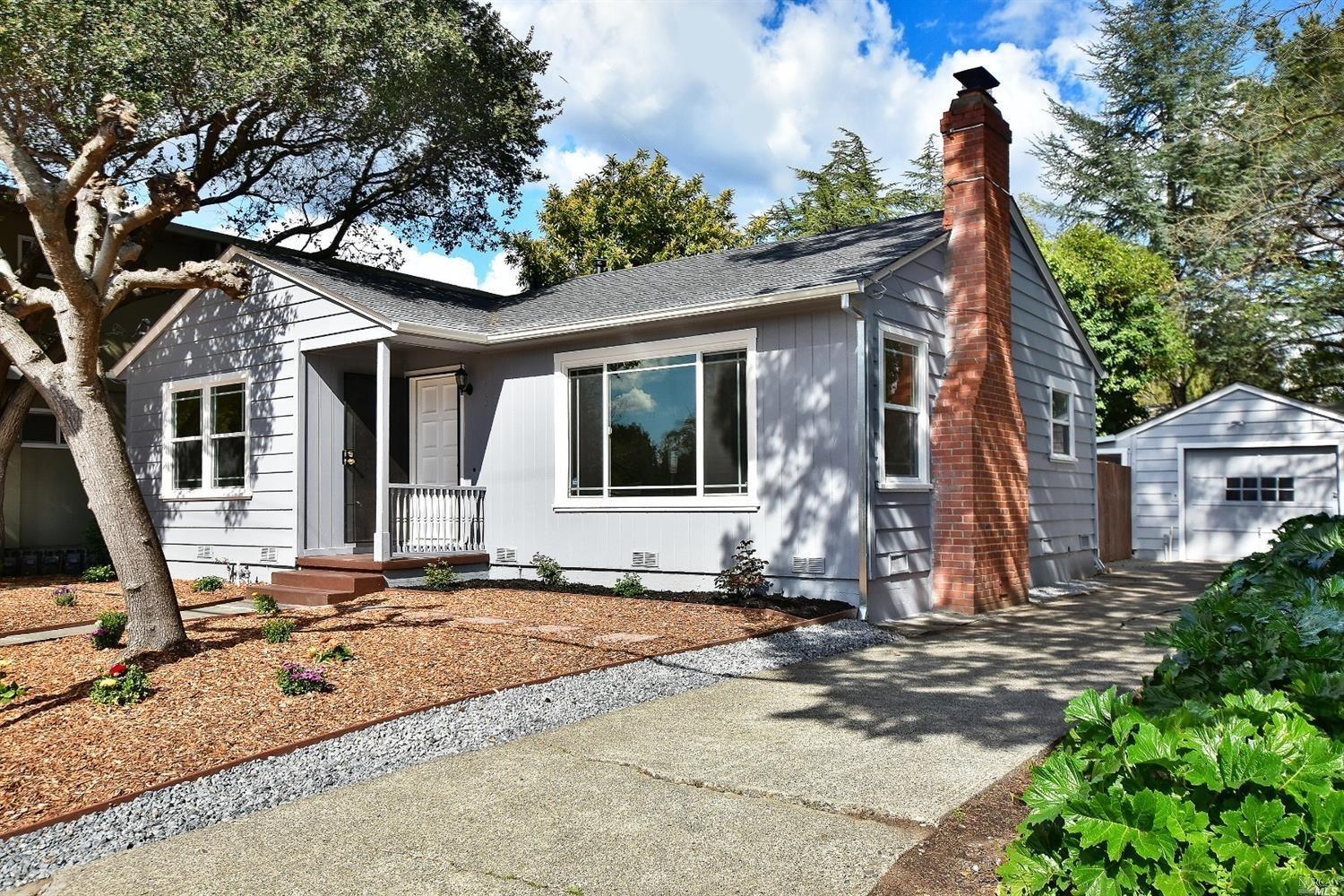 a front view of a house with a tree
