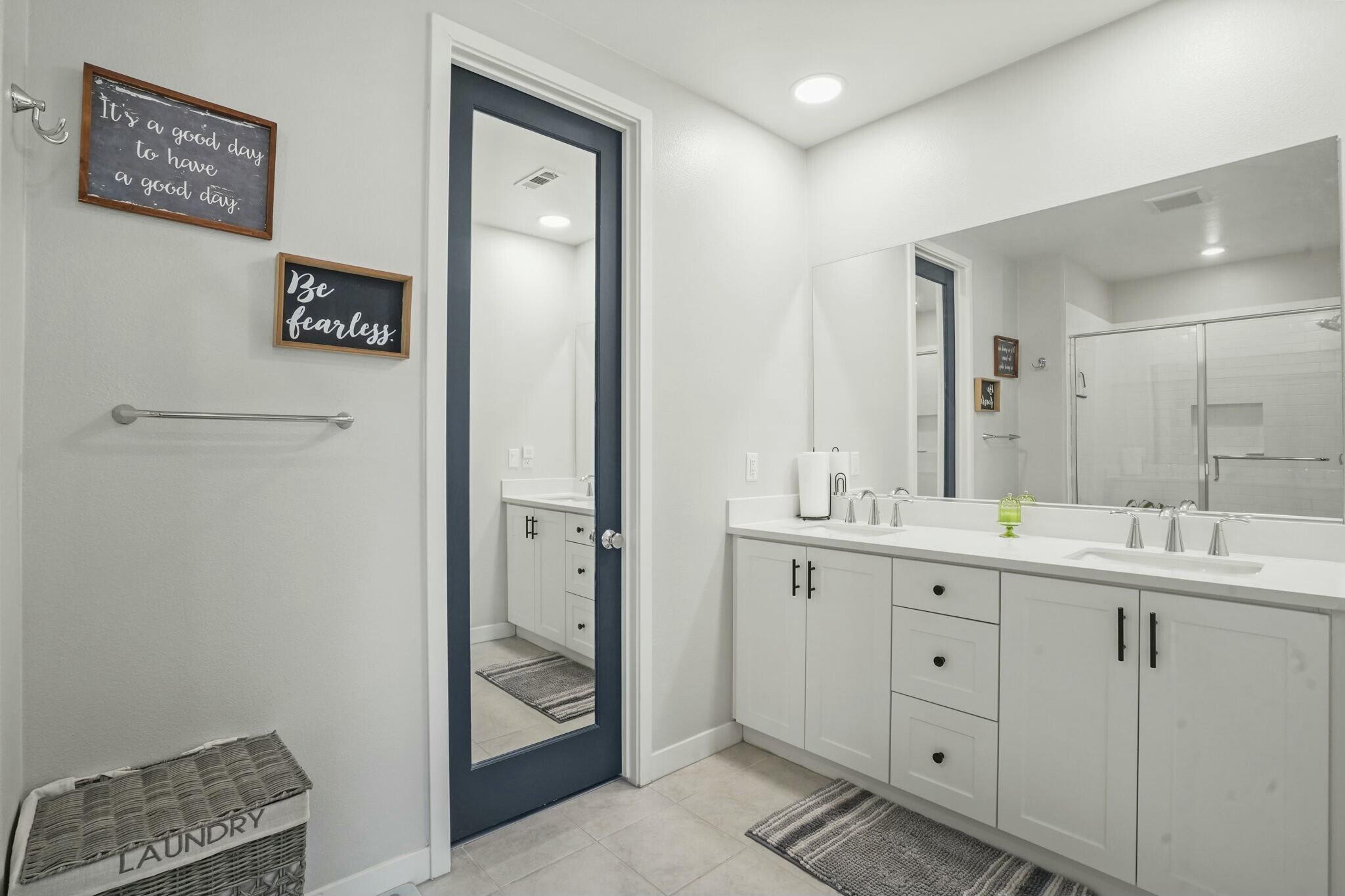 26976 West Prospector Road, Unit 205 Valencia, CA 91381 - Photo 18 of 31 a bathroom with a double vanity sink and mirror