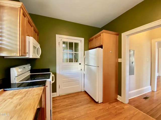 a kitchen with stainless steel appliances granite countertop a refrigerator and a stove