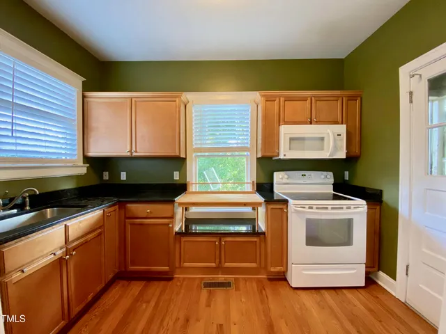 a kitchen with a stove a sink and a microwave