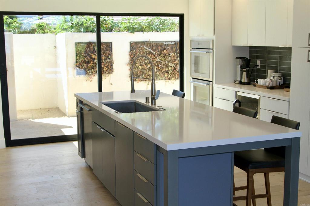 6173 Paseo Arbolado Rancho Santa Fe, CA 92067 - Photo 6 of 16 a kitchen with a sink a counter and a view of living room