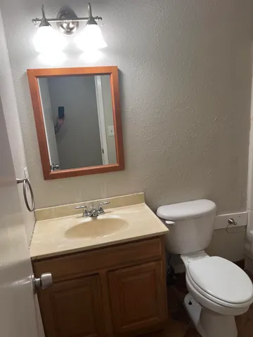 a bathroom with a toilet sink and mirror