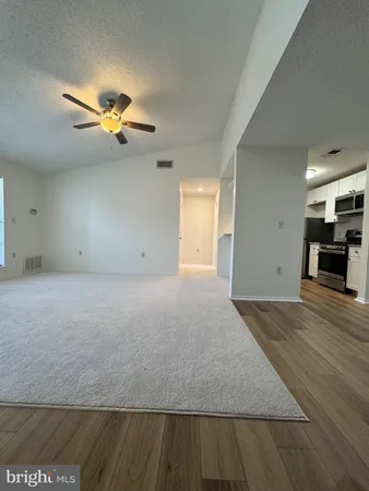 a view of a big room with wooden floor and a window