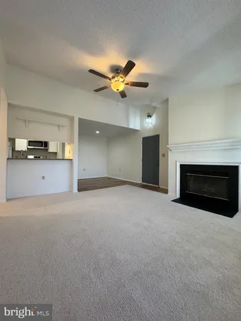 a view of a kitchen with a ceiling fan and a fireplace