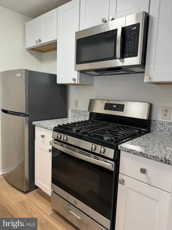 a kitchen with stainless steel appliances granite countertop a stove and a microwave