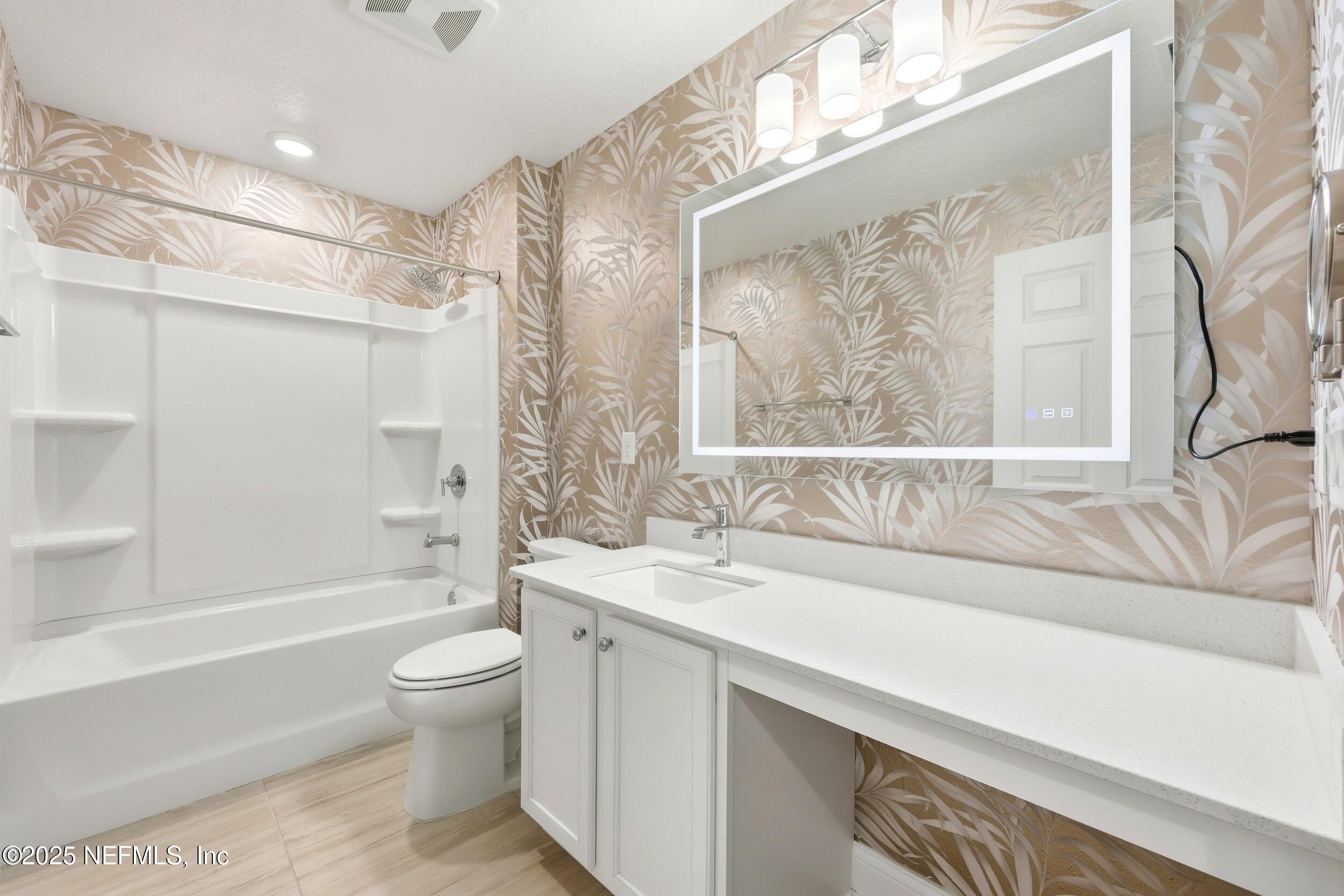 251 Rambling Brk Trail St. Johns, FL 32259 - Photo 35 of 40 a bathroom with a granite countertop sink a toilet a large mirror and a bathtub