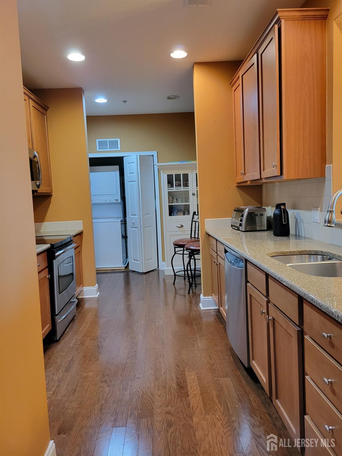 100 Middlesex Boulevard, Unit 341 Plainsboro, NJ 08536 - Photo 2 of 16 a kitchen with stainless steel appliances sink refrigerator and microwave