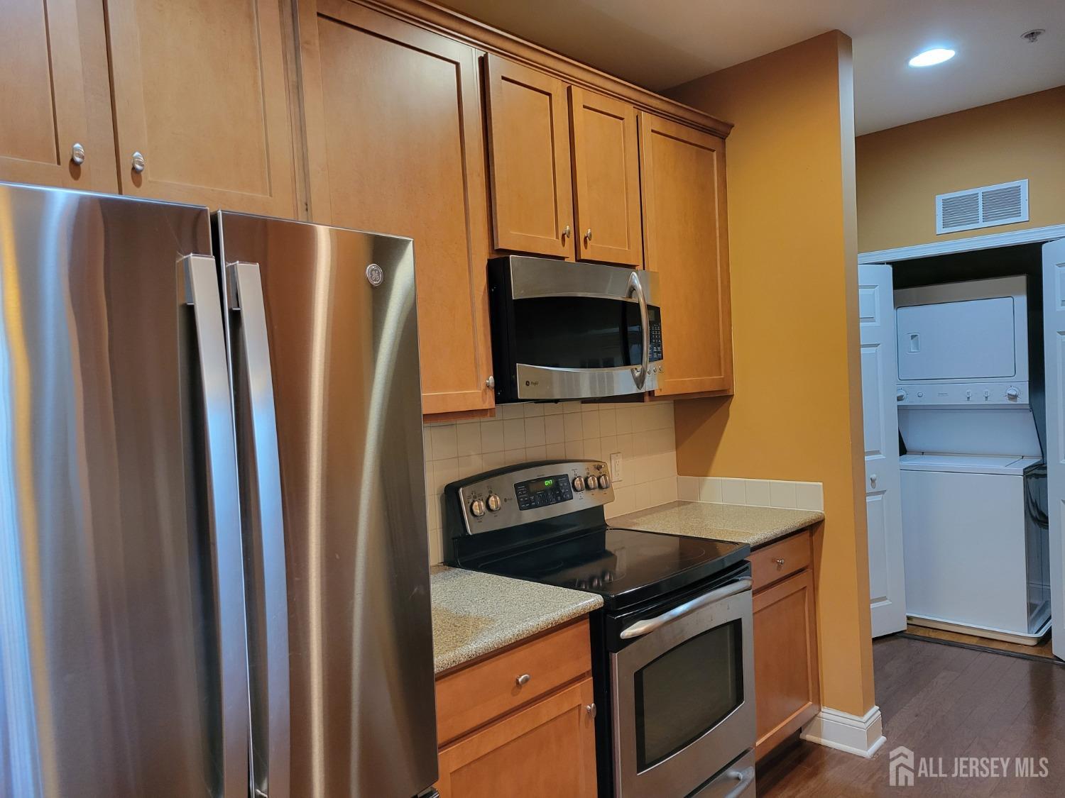 100 Middlesex Boulevard, Unit 341 Plainsboro, NJ 08536 - Photo 3 of 16 a kitchen with stainless steel appliances granite countertop a refrigerator stove and microwave