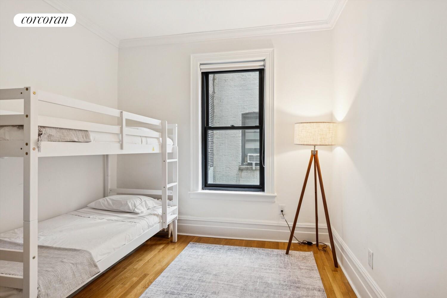 61 East 86th Street, Unit 76 Manhattan, NY 10028 - Photo 10 of 17 a bedroom with a bed and a window