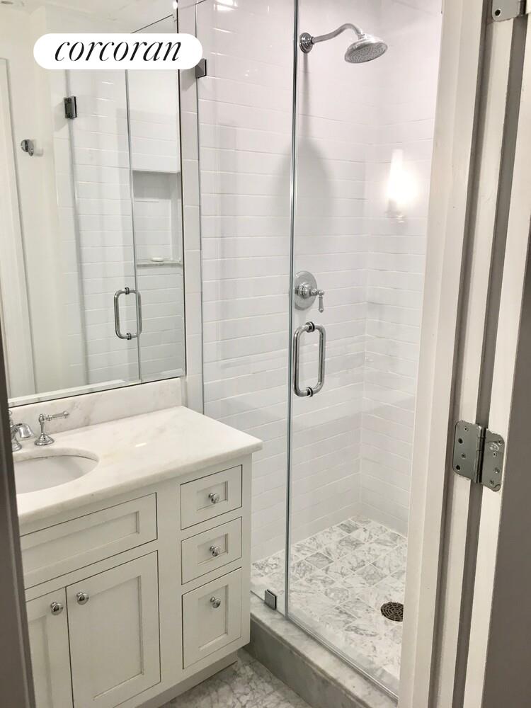 61 East 86th Street, Unit 76 Manhattan, NY 10028 - Photo 12 of 17 a bathroom with a shower sink and mirror