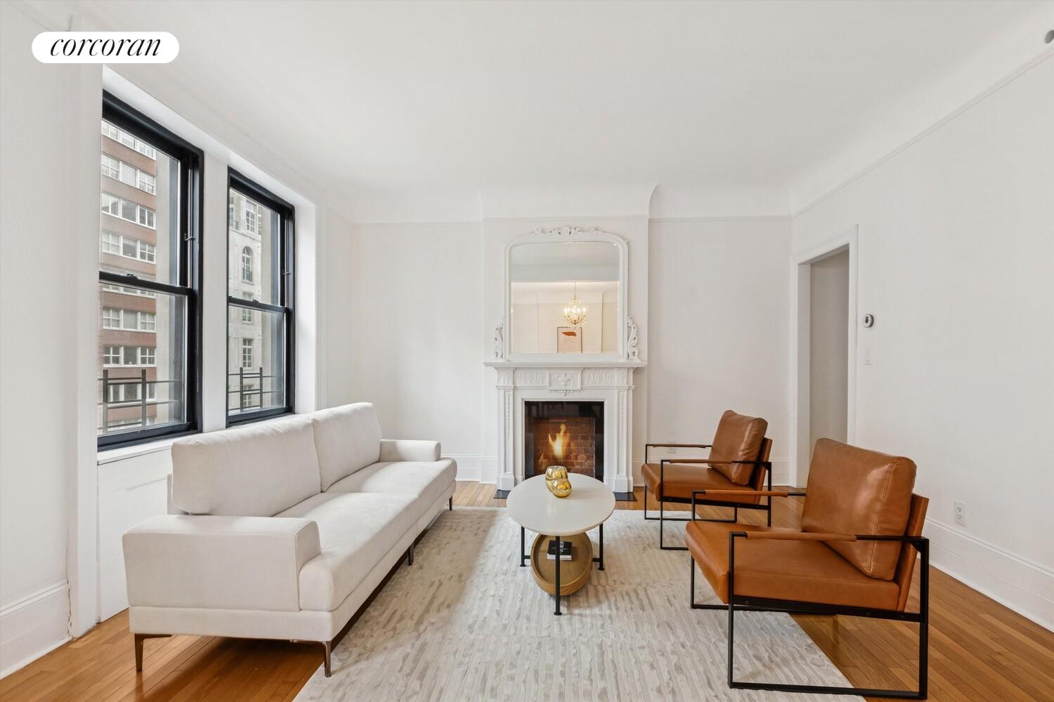 a living room with furniture a fireplace and a large window