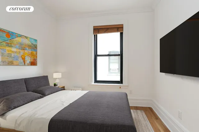 a bedroom with a bed and painting on the wall