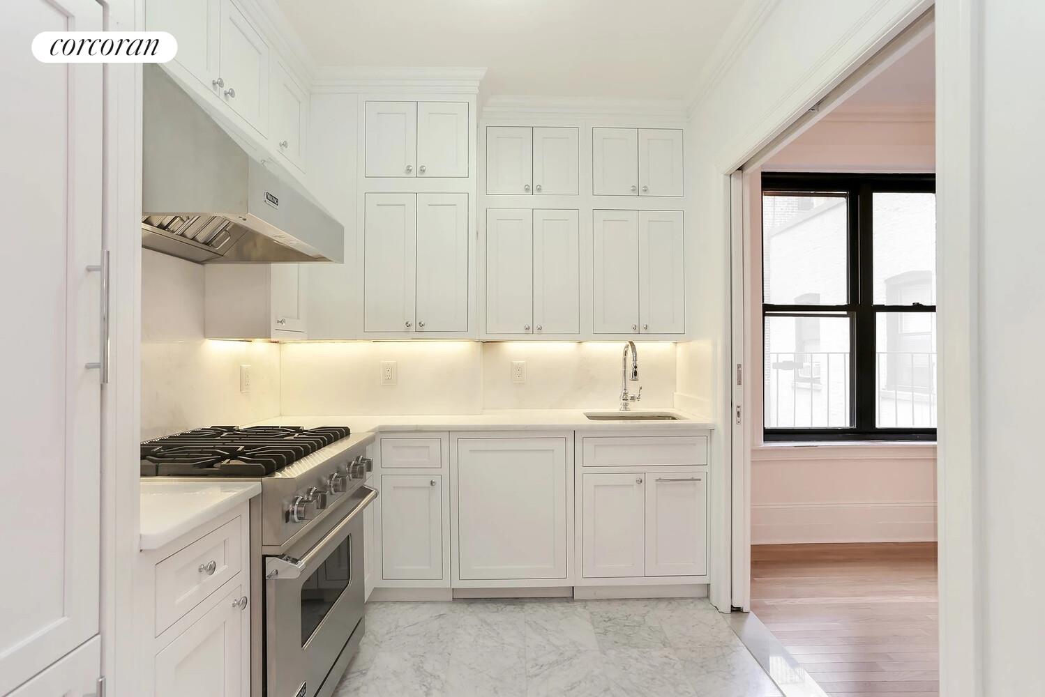 61 East 86th Street, Unit 76 Manhattan, NY 10028 - Photo 5 of 17 a kitchen with granite countertop white cabinets and white appliances