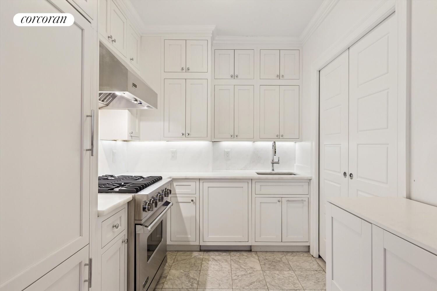 61 East 86th Street, Unit 76 Manhattan, NY 10028 - Photo 6 of 17 a kitchen with white cabinets and white appliances