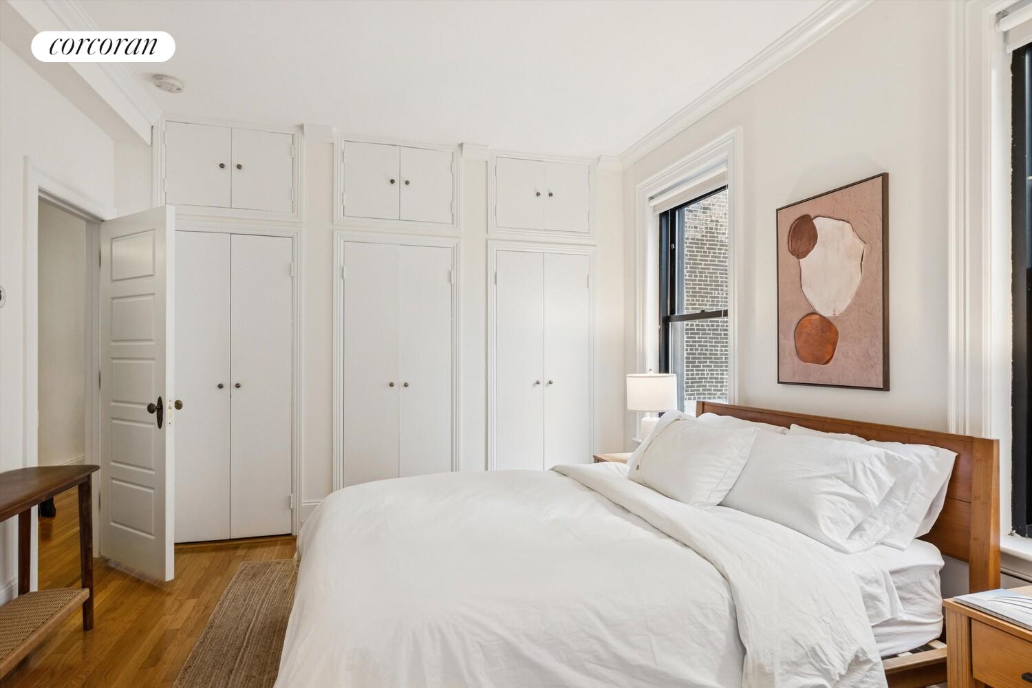 61 East 86th Street, Unit 76 Manhattan, NY 10028 - Photo 8 of 17 a bedroom with a bed and wooden floor