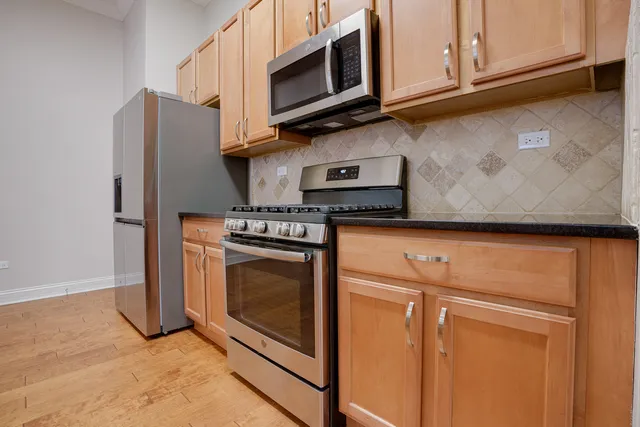 a kitchen with stainless steel appliances granite countertop a stove microwave and sink