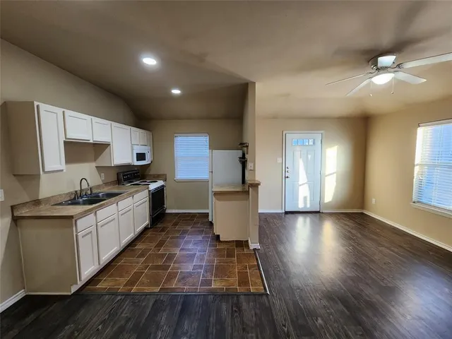 a large kitchen with stainless steel appliances granite countertop a stove and a refrigerator
