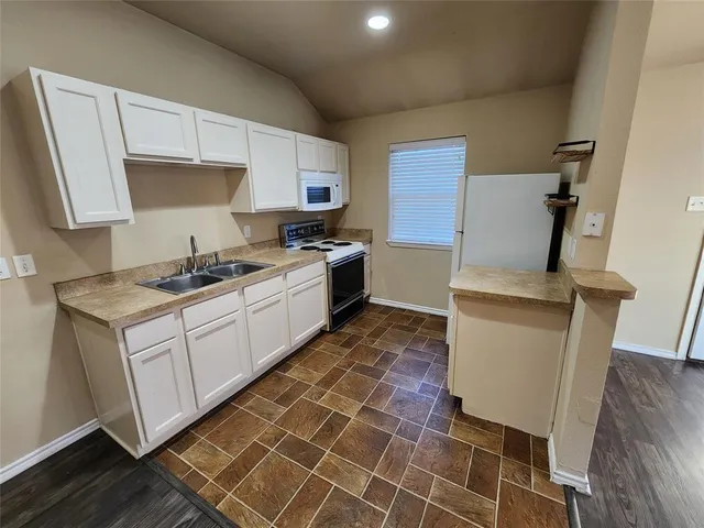 a kitchen with a sink appliances and cabinets