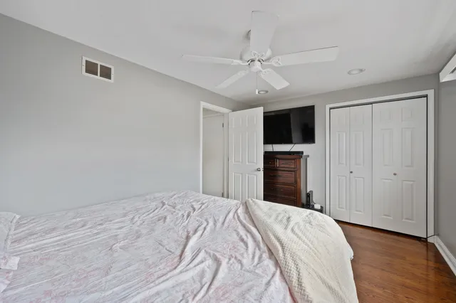 a bedroom with a large bed and a flat tv screen