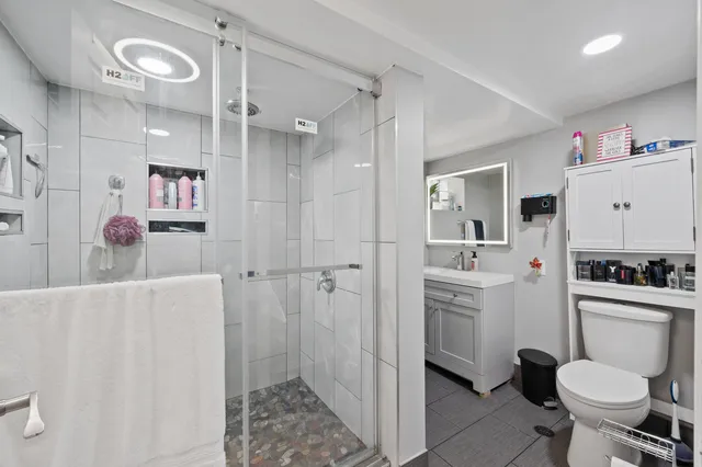 a bathroom with a sink toilet vanity and shower