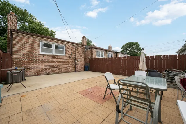 a backyard of a house with table and chairs