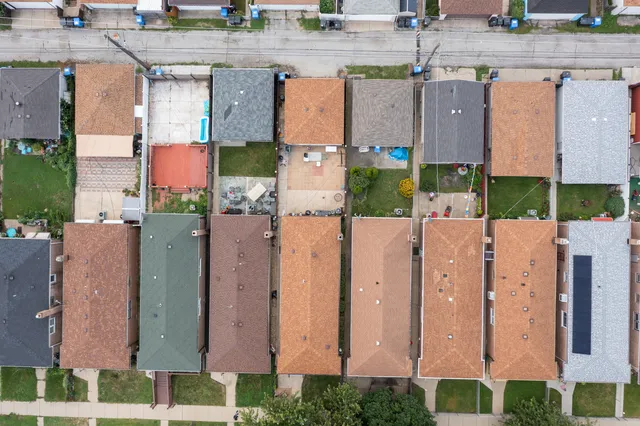 an aerial view of residential houses with outdoor space and parking