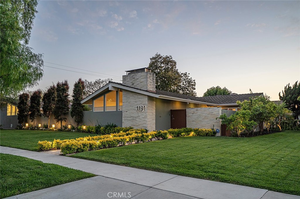 a front view of a house with a garden and plants