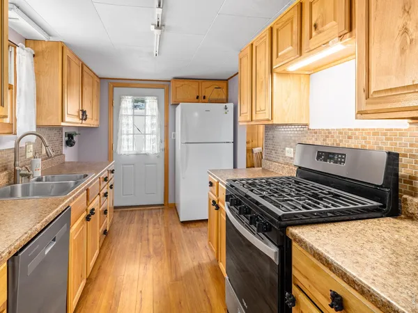 a kitchen with granite countertop a stove and a refrigerator