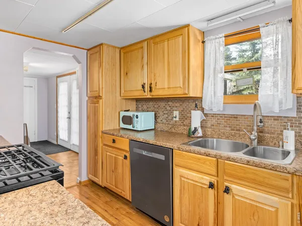 a kitchen with a sink a stove cabinets and a window