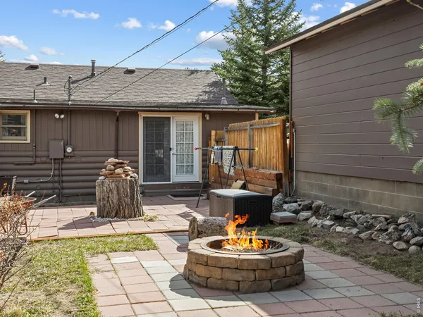 a outdoor space with the couches potted plants and a fireplace