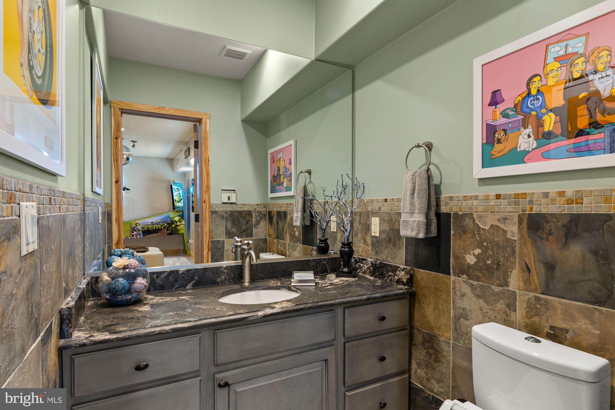 7400 Nevis Road Bethesda, MD 20817 - Photo 40 of 47 a bathroom with a granite countertop sink a toilet and a mirror