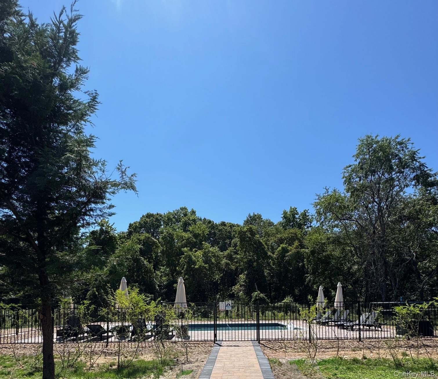 750 Kerwin Boulevard Greenport, NY 11944 - Photo 19 of 21 a view of a swimming pool with lawn chairs under an umbrella