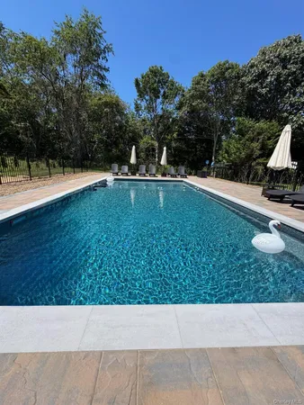 a view of swimming pool and trees in the background