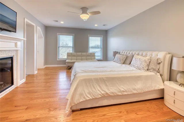 a spacious bedroom with a bed and a flat screen tv