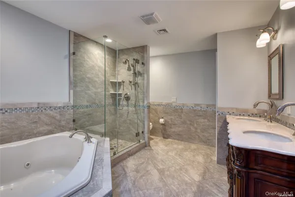 a bathroom with a tub sink shower and mirror