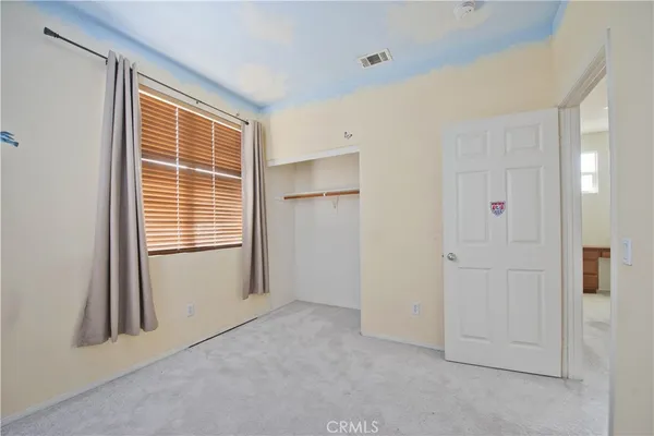 a big room with closet and a ceiling fan