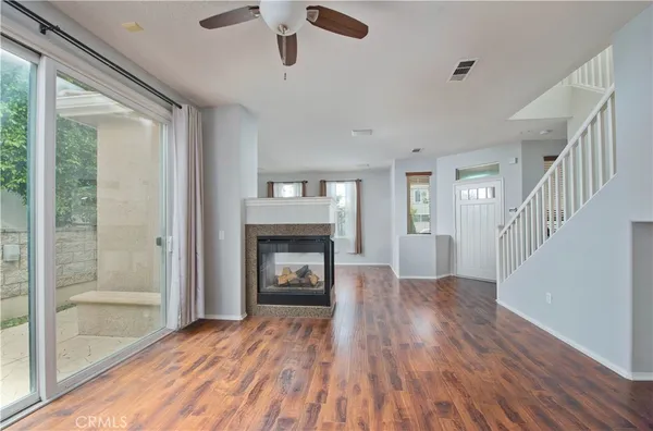 a view of an empty room with a window and kitchen view