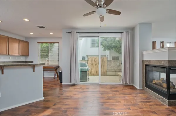 a kitchen with stainless steel appliances granite countertop a sink a stove a refrigerator cabinets and wooden floor