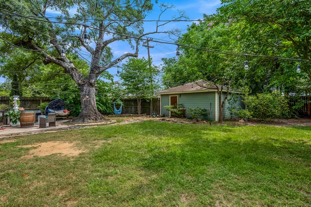 a view of a house with a backyard and a tree