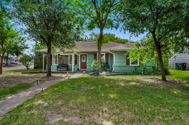 a front view of a house with a yard and trees