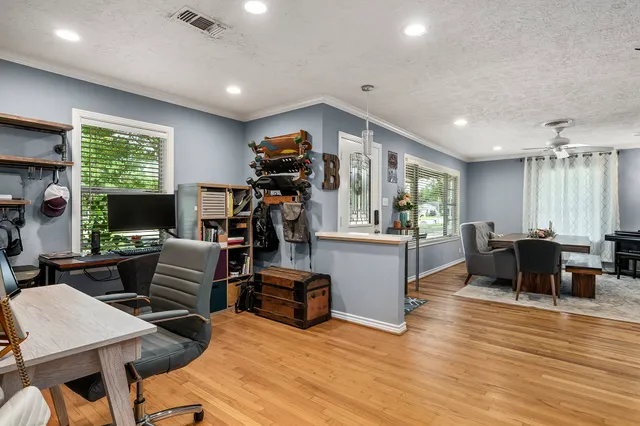 a living room with furniture flat screen tv and a large window