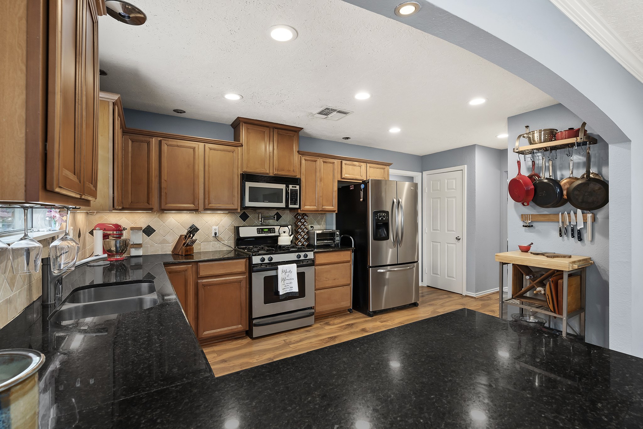 1034 Nashua Street Houston, TX 77008 - Photo 8 of 19 a kitchen with stainless steel appliances granite countertop a refrigerator a stove top oven a sink dishwasher and wooden cabinets with wooden floor