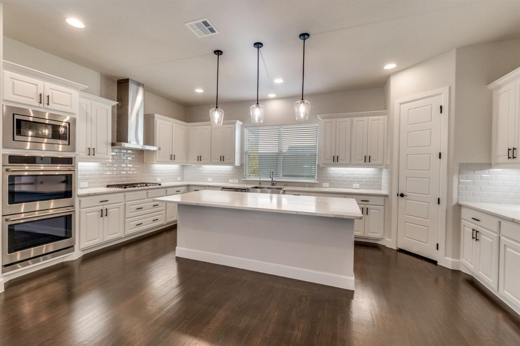 8202 Laflin Lane Dallas, TX 75231 - Photo 12 of 22 a large kitchen with cabinets wooden floor and stainless steel appliances