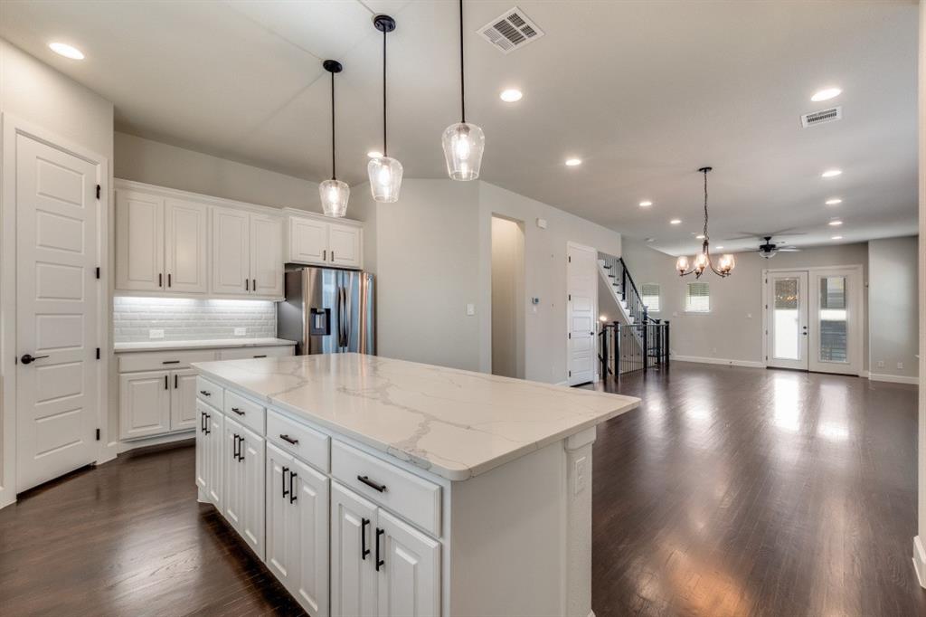 8202 Laflin Lane Dallas, TX 75231 - Photo 14 of 22 a large kitchen with kitchen island a stove a sink a refrigerator and a view of living room