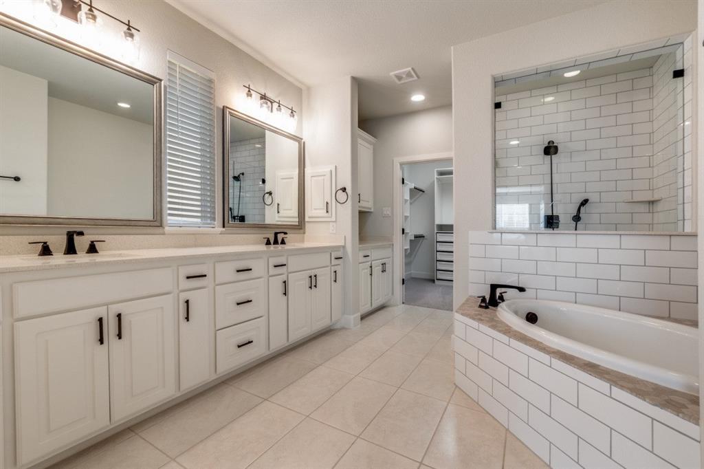 8202 Laflin Lane Dallas, TX 75231 - Photo 20 of 22 a spacious bathroom with double sink a large mirror and a bathtub