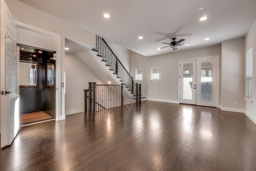 8202 Laflin Lane Dallas, TX 75231 - Photo 8 of 22 an empty room with wooden floor staircase and windows